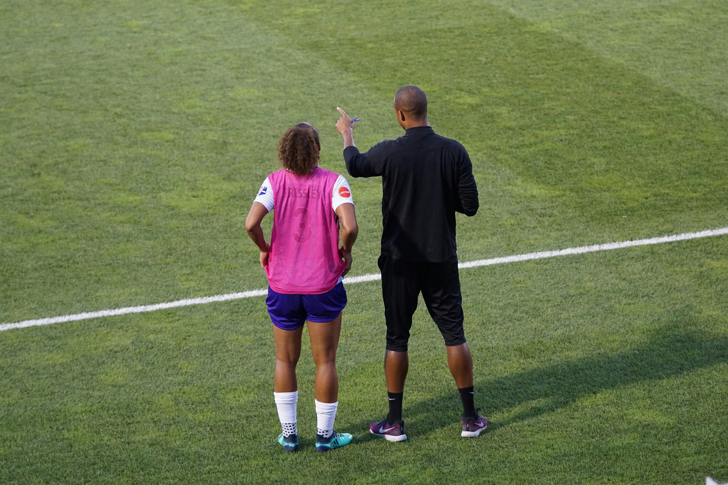Entraîneur avec une joueuse de foot.
